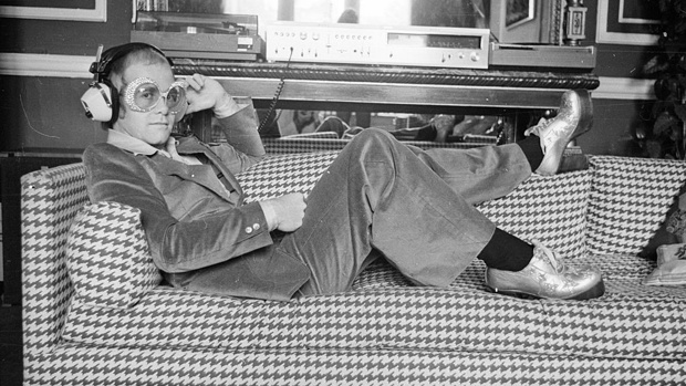 12th September 1974: English pop star Elton John relaxes on a sofa and listens to some music. (Photo by D. Morrison/Express/Getty Images)
