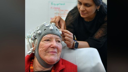 Dr Divya Adhia attaches cables to a cap covered with electrodes, which unexpectedly helped to restore Dunedin author Dr Lynley Hood’s vision recently. Photo / Stephem Jaquiery