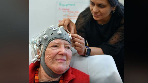Dr Divya Adhia attaches cables to a cap covered with electrodes, which unexpectedly helped to restore Dunedin author Dr Lynley Hood’s vision recently. Photo / Stephem Jaquiery
