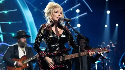 Dolly Parton jokes she’ll ‘hopefully drop dead in the middle of a song’ before she ever retires